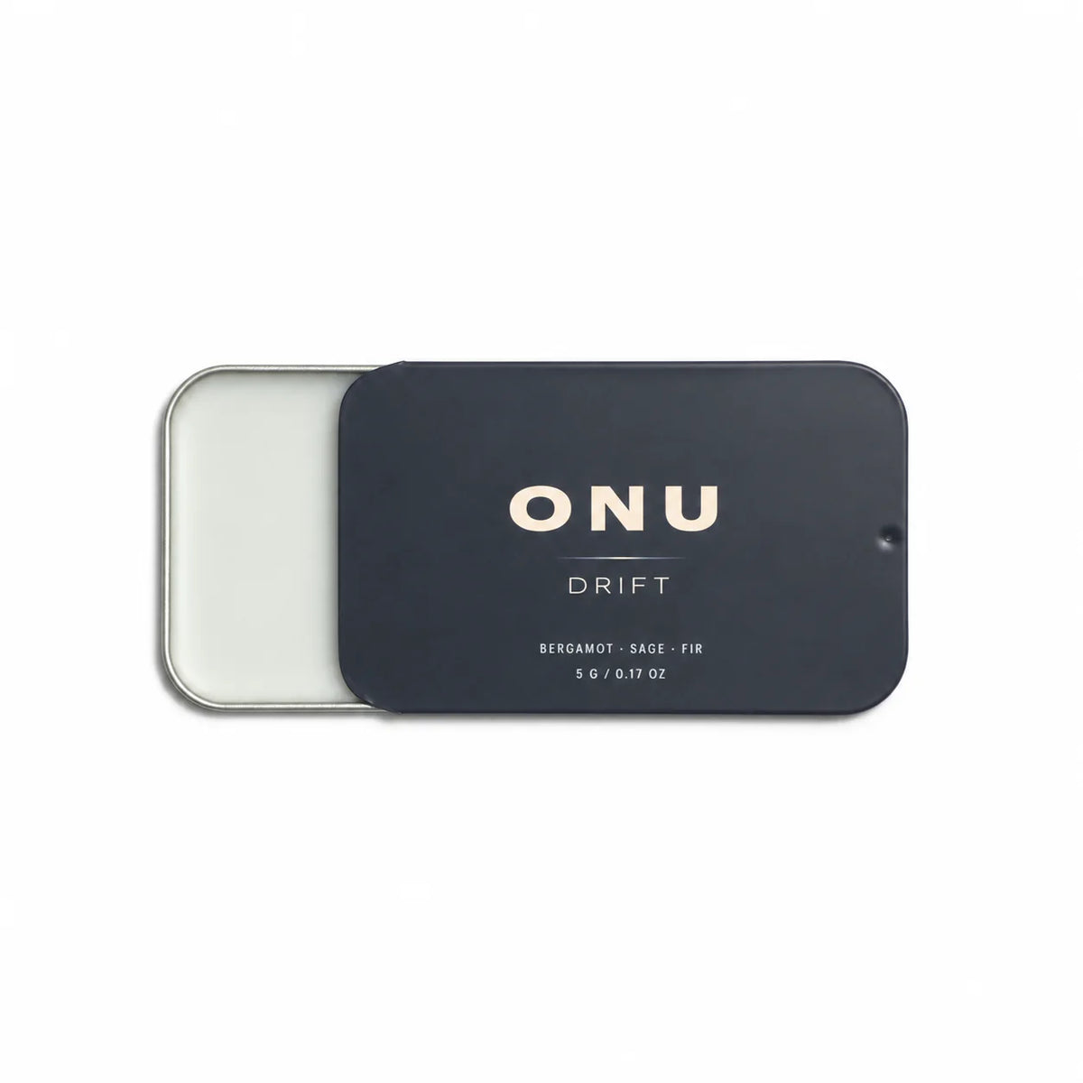 Open deep navy ONU DRIFT solid balm cologne card showing the white balm on a clean white background.