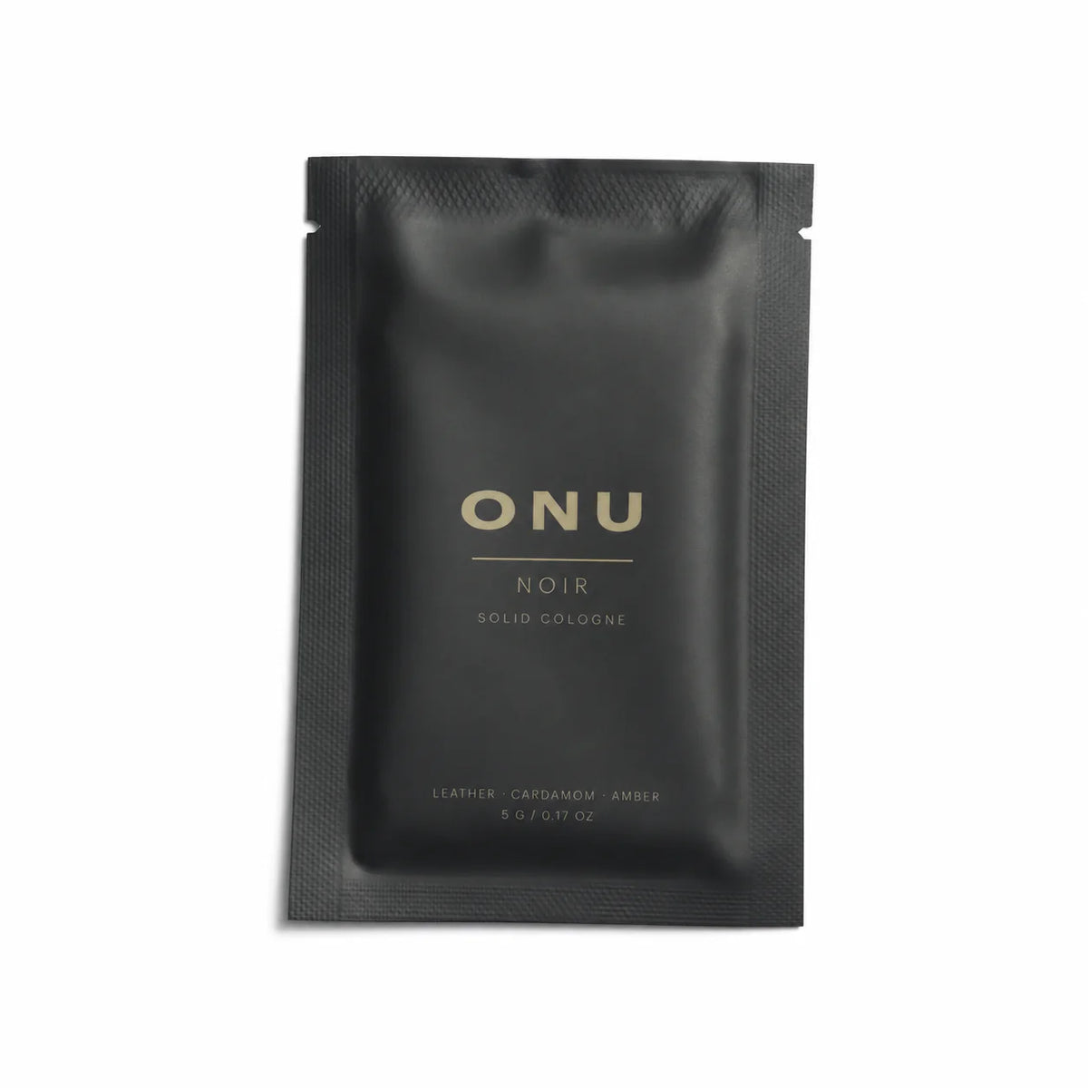 Black ONU NOIR solid balm cologne sachet on a clean white background.